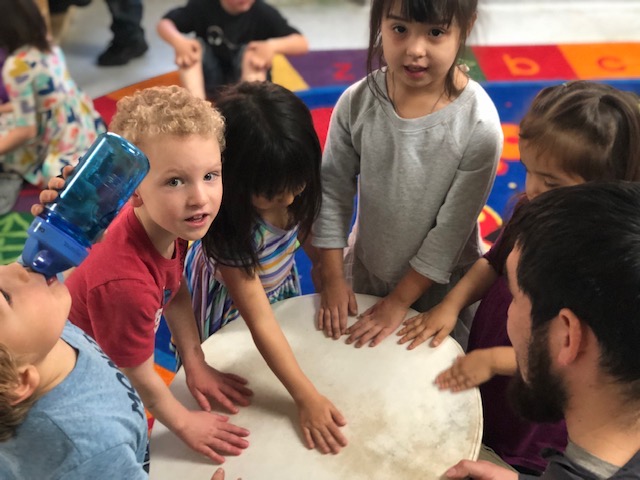 Photo 6. Head Start students examining traditionally made drum. Photo courtesy of Kawerak, Inc.